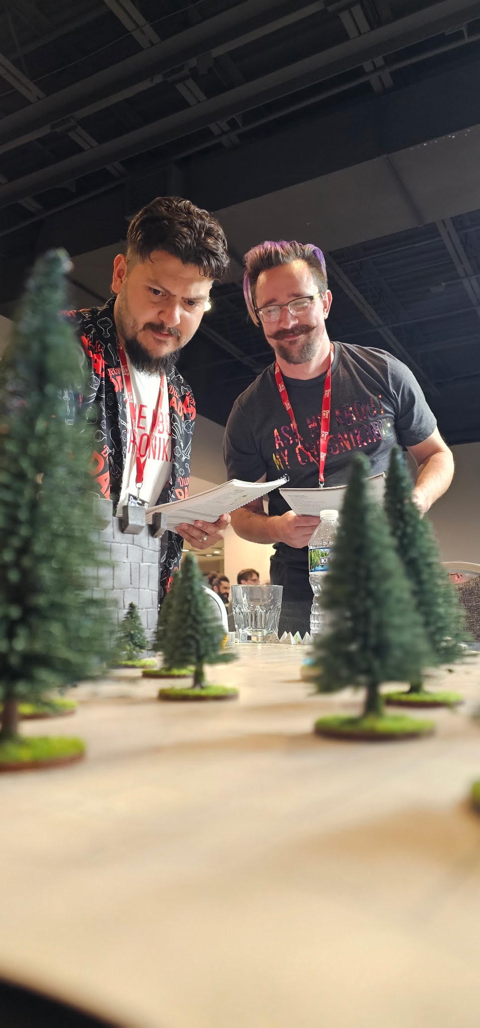 Jeremy and Wesley, co-founders of Black Mack Studios, holding the first test print of Chronicles of Myth at a gaming convention